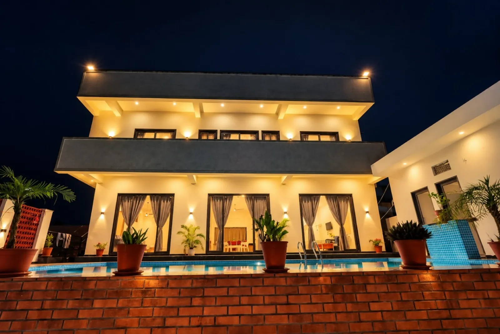 5 BHK villa in Udaipur with a stunning illuminated facade, private pool, and spacious landscaped outdoor area
