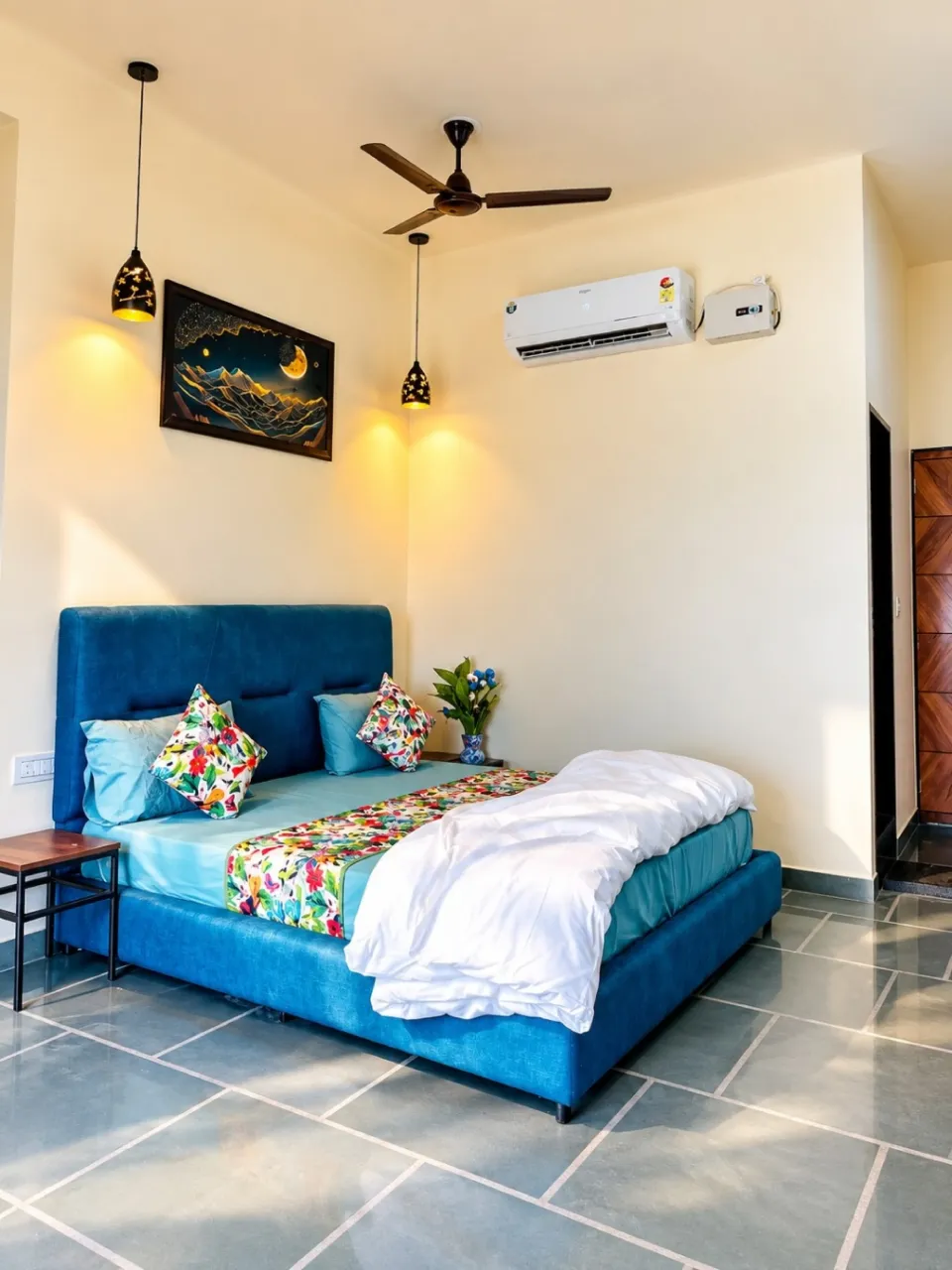 Chic blue bed with floral decor, pendant lighting, air conditioning, tiled floors, and a refreshing hill view